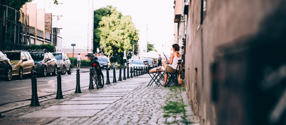 picography-a-woman-reads-a-newspaper-outside-a-cafe